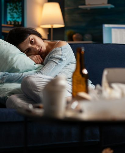 Anxious woman with depression laying on couch at home